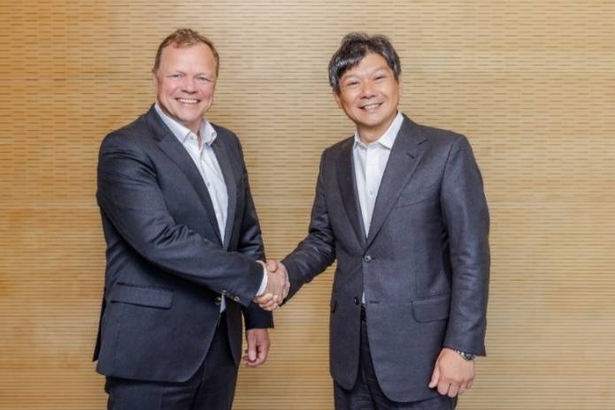 Two men in suits shaking hands AI-generated content may be incorrect.