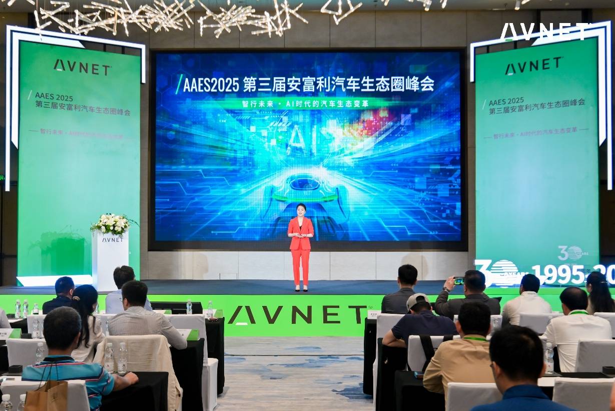 A person standing on a stage with a large screen AI-generated content may be incorrect.