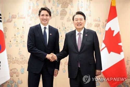 资料图片:5月17日,在首尔龙山总统府,韩国总统尹锡悦(右)和加拿大总理贾斯廷·特鲁多在举行会谈前合影留念。 韩联社